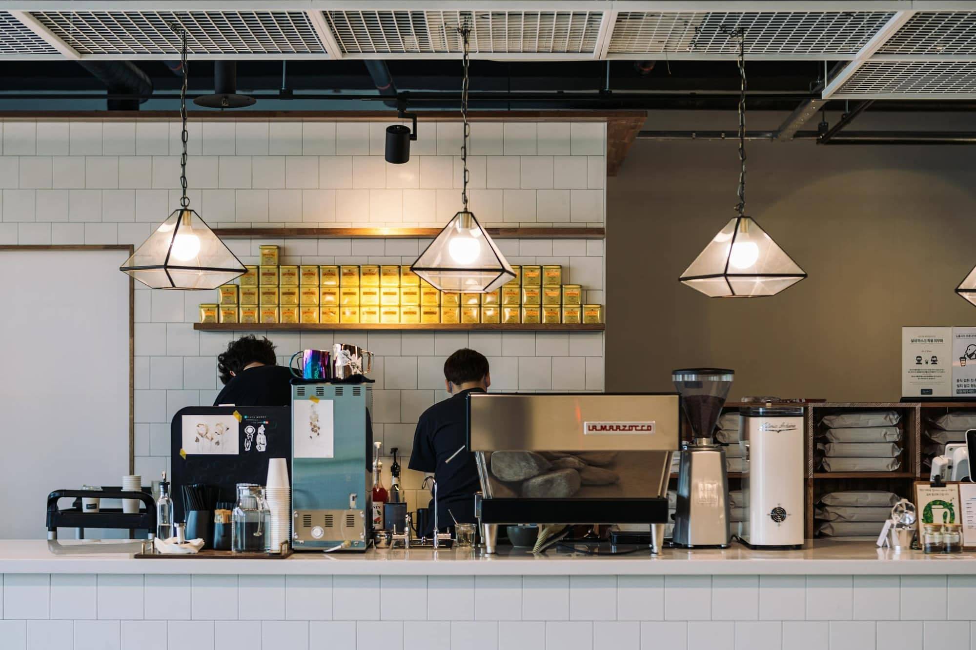 A bright café counter with customers seated nearby