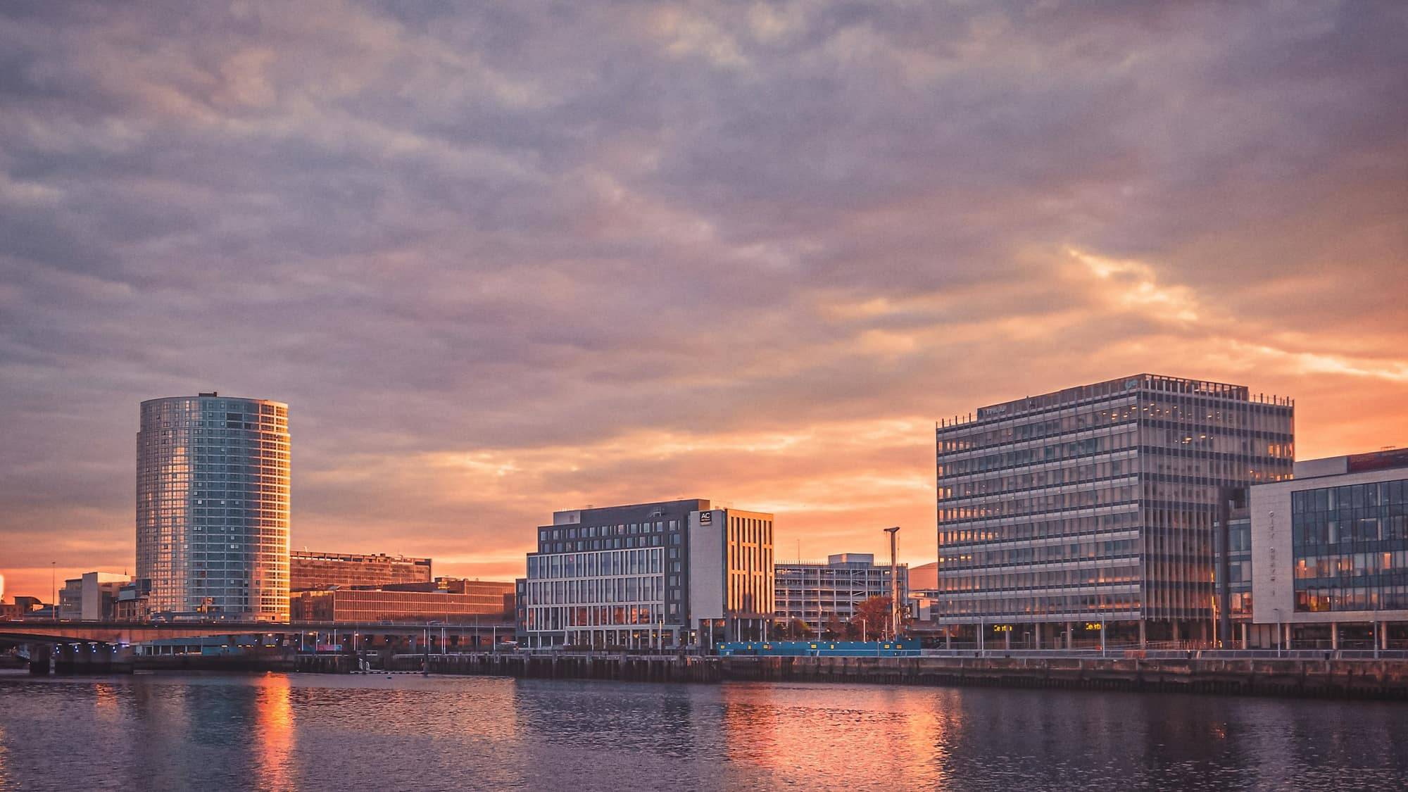 Belfast's waterfront buildings reflected in the River Lagan at sunset
