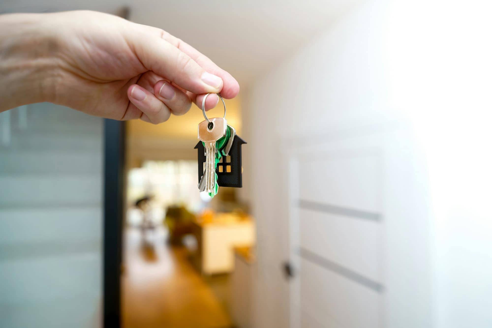 Holding up a set of house keys at a front door